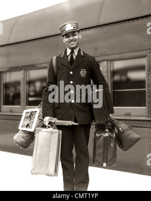 1930S 1940S PORTRAIT LÄCHELND AFROAMERIKANISCHE MANN ROTE KAPPE PORTER TRAGEN GEPÄCK TASCHEN KOFFER PASSAGIERZUG EISENBAHN Stockfoto