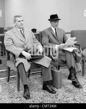 1950S 1960S ZWEI MÄNNER GESCHÄFTSMANN VERKÄUFER SITZEN IM BÜRO REZEPTION WARTEBEREICH INNEN Stockfoto