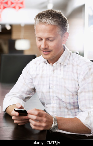 Geschäftsmann schickt SMS über Handy Stockfoto