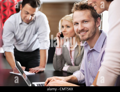 Glücklich Kaufmann mit Team mit Laptop in einer Sitzung Stockfoto