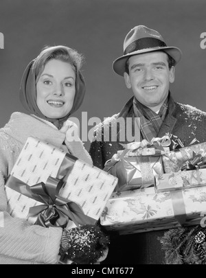 1960ER JAHREN PAAR MANN UND FRAU HOLDING EINGEBUNDENEN WEIHNACHTEN GESCHENKE UND PAKETE Stockfoto
