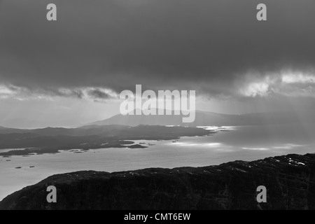 Einen stimmungsvollen Blick über Loch Carron in Richtung Plockton.  Ein Sturm zieht auf und Sonnenstrahlen auf der Wasseroberfläche Stockfoto