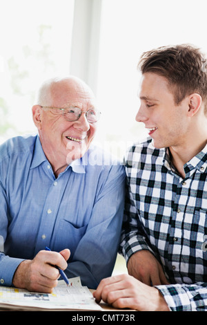 Glücklich senior Mann und Enkel Kreuzworträtsel zu lösen Stockfoto