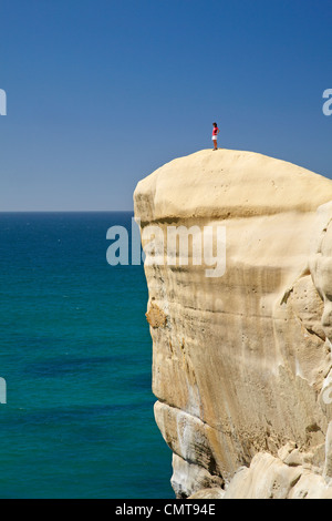 Touristen auf Klippe am Tunnel Beach, Dunedin, Südinsel, Neuseeland Stockfoto