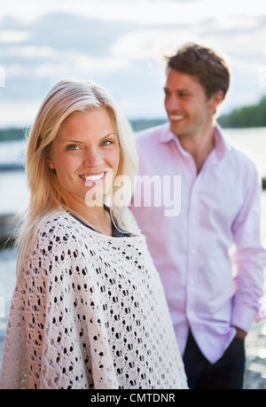 Porträt der jungen Frau mit Mann im Hintergrund Stockfoto