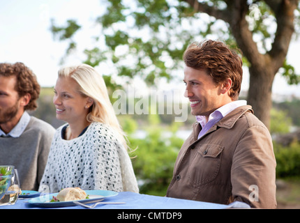 Drei Freunde, die Abendessen im freien Stockfoto