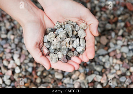 Nahaufnahme der Hand einer Person, die einen Steinwurf Stockfoto