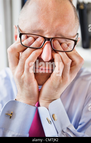 Betont Man, die Augen mit den Fingern reiben Stockfoto