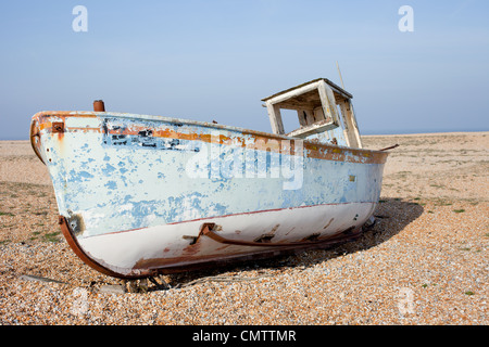 Altes Fischerboot am Strand vor einem strahlend blauen Himmel. Stockfoto