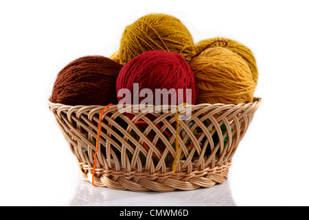wicker basket with colorful balls of wool on a white background Stockfoto
