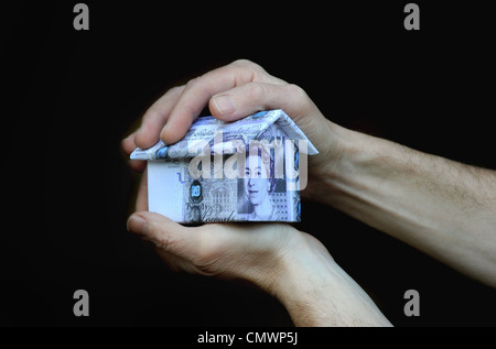 HAUS AUS 20 PFUND NOTEN IN MANS HAND RE HAUS PREISE WERTE EIGENSCHAFT MARKT KAUF VERKAUF VON EIGENHEIMEN KOSTEN HYPOTHEKEN ETC. UK Stockfoto