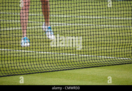 Tennisspielerin spielt Tennis auf einem Rasenplatz Stockfoto