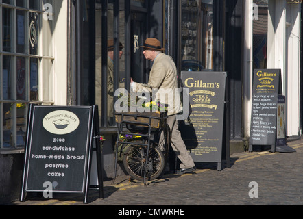 Ältere Mann zu Fuß in Gillams Shop & Café in der Stadt von Ulverston, Cumbria, England UK Stockfoto