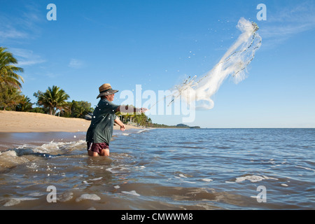 Mann wirft Netz ins Meer geworfen.  Machans Beach, Cairns, Queensland, Australien Stockfoto