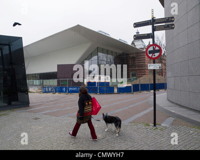 Frau mit ihrem Hund zu Fuß auf dem Museumplein Platz vor der neuen Erweiterung für umstrittene Stedelijk Museum in Amsterdam Stockfoto