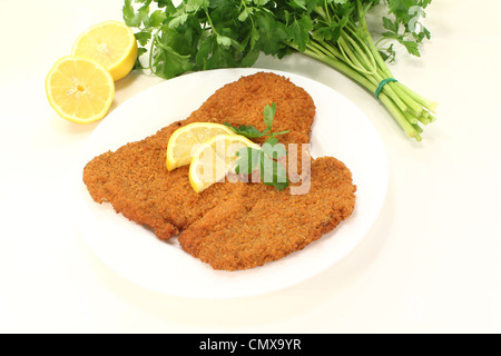 frisch gerösteten Wiener Schnitzel mit Zitronenscheiben und Petersilie Stockfoto