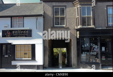 Ein indisches Restaurant und Imbiss direkt neben einem Tattoo-Studio in Helston, Cornwall. Stockfoto