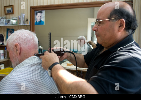 London Ontario, Kanada - 28. März 2012. Vincenzo Ioele von "Vince es Barber Shop" kümmert sich Stammkunden George Stovel. Stockfoto