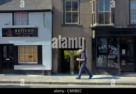 Ein indisches Restaurant und Imbiss direkt neben einem Tattoo-Studio in Helston, Cornwall. Stockfoto