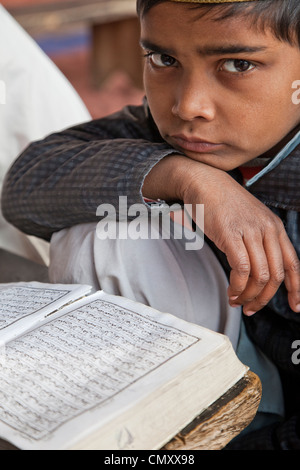 Agra, Indien. Young Boy und seinen Koran, Madrasa der Jama Masjid (Freitagsmoschee). Stockfoto