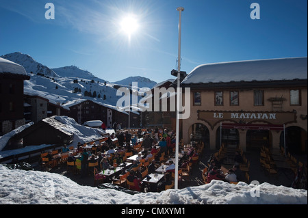 Le Matafin Restaurant Sonnenterrasse in Belle Plagne Höhe Skigebiet mit Ende März Schnee und Skifahrer Stockfoto