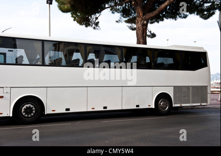 Die Seite von einem weißen Bus fahren auf der Straße an einem sonnigen Tag. Stockfoto