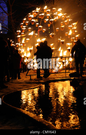 Paar Umarmung an wintercity Nächte der Fire globe durch cie carabosse in Toronto mit Reflexion im Wasser Stockfoto