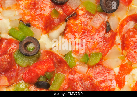 Makro Nahaufnahme Detail Pizza mit Käse, Peperoni, rote und grüne Paprika, Zwiebeln und schwarzen Oliven Stockfoto