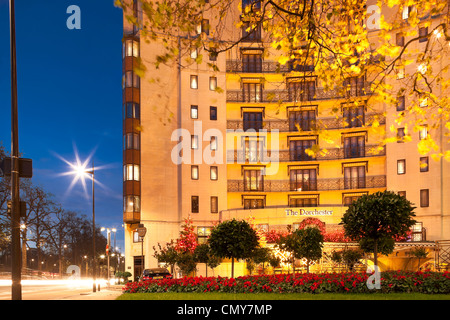 Das Dorchester Hotel Park Lane London mit Weihnachtsschmuck in der Abenddämmerung. Fünf-Sterne-Luxus-Hotel-Fassade in der Nacht. Helle Streifen. Stockfoto