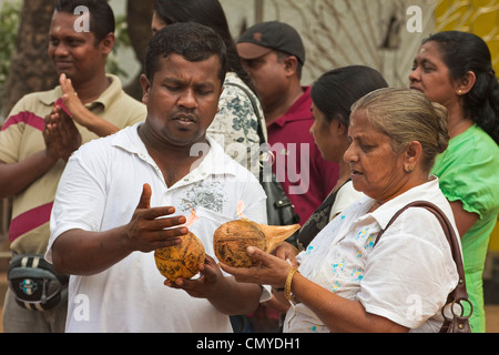 Anhänger, Vorbereitung, Kokosnüsse in einem Schrein in Maha Devale Tempel in dieser heiligen Stadt zu zerschlagen; Kataragama, Uva Provinz, Sri Lanka Stockfoto