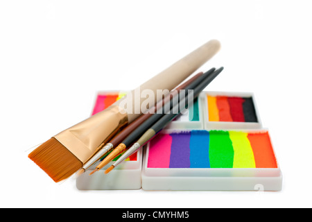 Gesicht-Farben Regenbogen Kuchen und Bürsten auf weißem Hintergrund Stockfoto