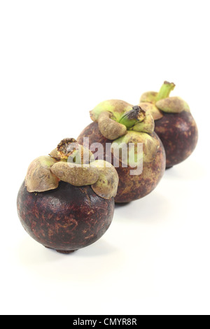 drei Mangostan-Früchte auf einem hellen Hintergrund Stockfoto