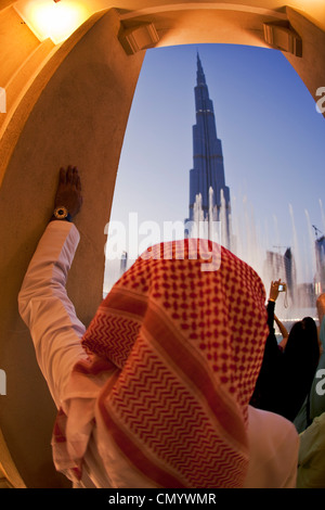 Arabische Mann beobachtet Dubai Fountain am Burj Khalifa, dem höchsten Skycraper in der Welt, der 828 Meter, Burj Dubai, Dubai UEA Stockfoto