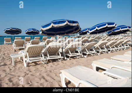 Unbesetzten liegen und Stühle am Strand entlang des Mittelmeers in Cannes, Frankreich. Stockfoto