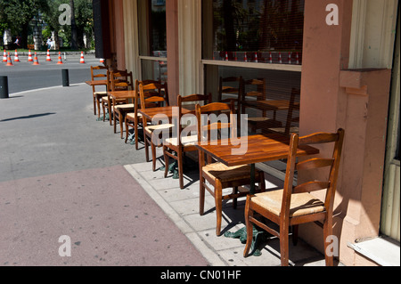 Eine Spalte mit hölzernen Stuhl und Tisch Setups auf einem Bürgersteig. Stockfoto