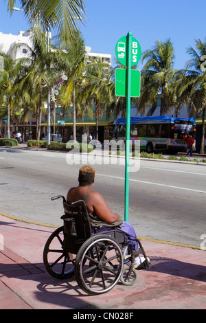 Miami Beach, Florida, Washington Avenue, schwarze Frau, weibliche Frauen, Rollstuhl, Bushaltestelle, warten, Behinderte spezielle Bedürfnisse, FL120114040 Stockfoto