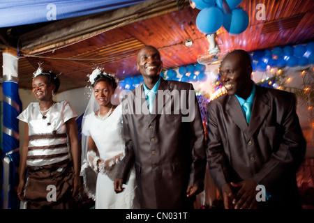 Eine Braut und Bräutigam feiern ihre Hochzeit mit ihren Begleitern in Tansania, Ostafrika. Stockfoto