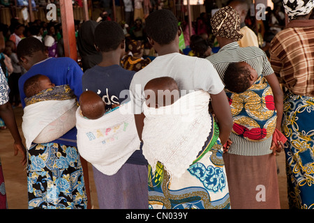 Frauen tragen ihre Babys auf dem Rücken am internationalen Frauentag Day Feierlichkeiten in Ngarama, Ruanda. Stockfoto