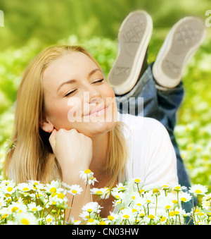 Schöne Frau Daisy Feld, schöne Welpen liegen auf der Wiese mit Blumen, hübsches Mädchen im Freien entspannen, Spaß zu genießen Stockfoto