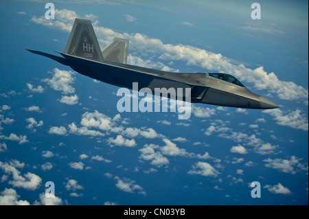 Ein F-22 Raptor aus dem 19. Jagdgeschwader, Joint Base Pearl Harbor-Hickam, Hawaii, wartet auf seine Reihe, als sein Flügelmann am 27. März 2012 über dem Pazifik nahe den Hawaii-Inseln Treibstoff aus einem 96. Lufttanker KC-135 Stratotanker nimmt. Während dieser Betankungsmission erhielten die Kadetten der Air Force Academy in der Frühjahrspause einen Einarbeitungsflug, um den Kadetten ein besseres Verständnis der globalen Reichweitenfähigkeiten der Air Force zu vermitteln. Stockfoto