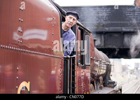 Dampflok zieht einen Personenzug auf der Great Central Railway - Lokführer, die darauf warten, fahren Stockfoto