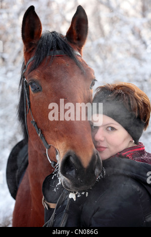 Mädchen mit ihrem Pferd in einer Schneelandschaft, konzentrieren sich auf das Mädchen Stockfoto