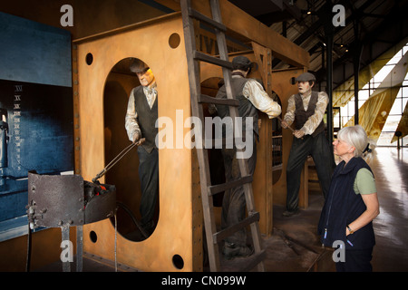 UK, Cumbria, Barrow in Furness, Dock Museum, Schiffbau Ausstellung, weibliche Besucher betrachten Nieten tableau Stockfoto