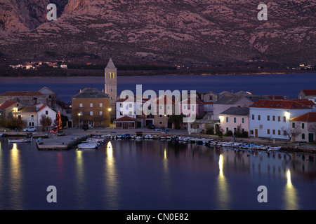 Kleine Küstenstadt Vinjerac in Kroatien am frühen Morgen mit ruhigen Meer, Reflexionen im Wasser und Berge im Hintergrund. Stockfoto