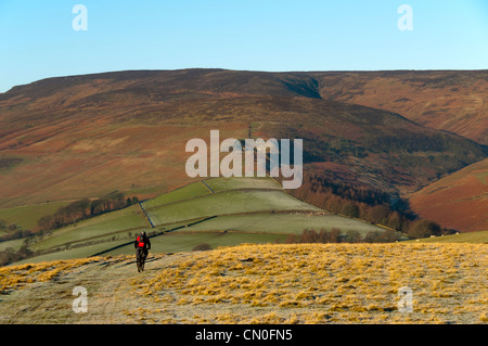 Mountainbiker auf die Hoffnung Brink Grat von Win Hill, Edale, Peak District, Derbyshire, England, UK. Kinder Scout Plateau hinter. Stockfoto