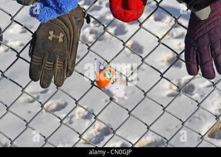 Verloren, Handschuhe und Hüte, die von einem Park Pfad, der einem Maschendrahtzaun befestigt Stockfoto