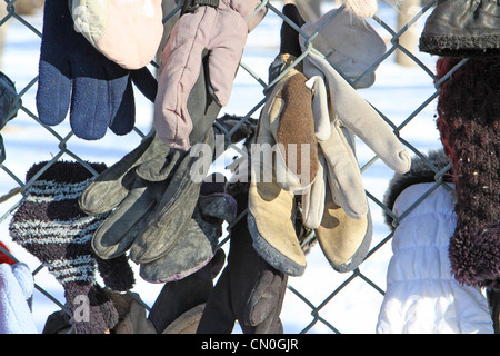 Verloren, Handschuhe und Hüte, die von einem Park Pfad, der einem Maschendrahtzaun befestigt Stockfoto