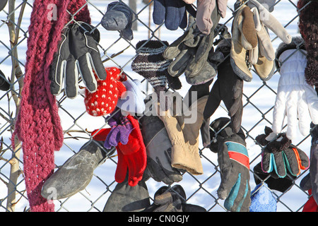 Verloren, Handschuhe und Hüte, die von einem Park Pfad, der einem Maschendrahtzaun befestigt Stockfoto