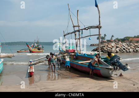 Sri Lankan Fischer werfen ihre outrigger Katamaran von Galle Sri Lanka Stockfoto