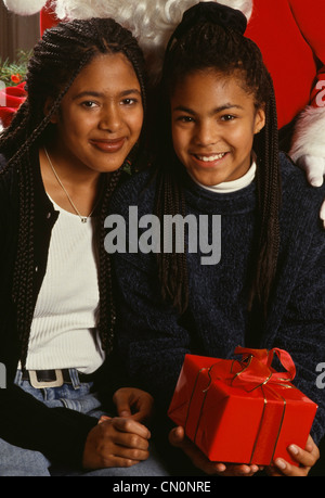 Schwestern posieren vor dem Weihnachtsmann. Vintage 1990er Jahre Stockfoto